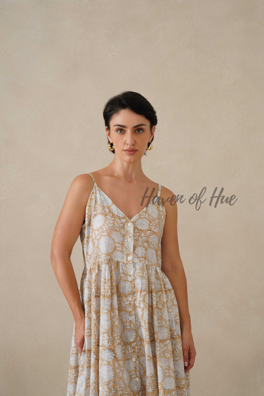Front view of a model in a beige and white floral cotton midi dress with a button-down front.