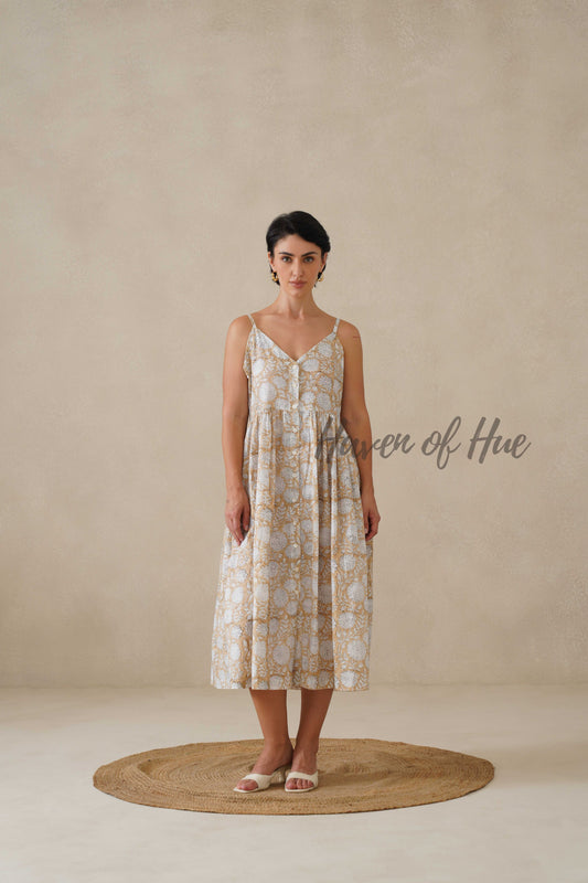 Lifestyle shot of a floral cotton midi dress in a neutral beige tone, perfect for a summer holiday.