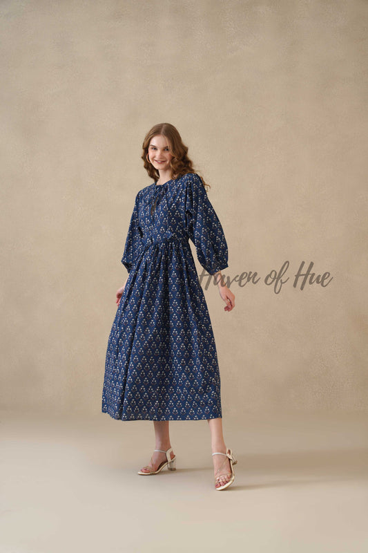 Close up of the intricate white floral vine motif on high-quality serene blue cotton fabric.